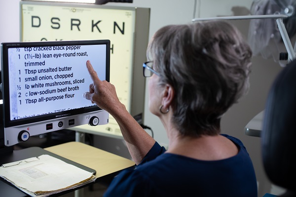 Woman reading text on a screen magnifier.